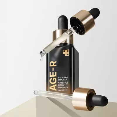 Frasco preto de ampola com conta-gotas dourado e líquido transparente