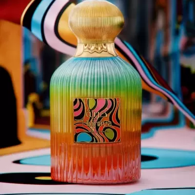 Frasco de perfume colorido com etiqueta abstrata e tampa dourada