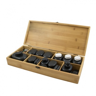 Conjunto de pedras de massagem e garrafas num estojo de madeira claro