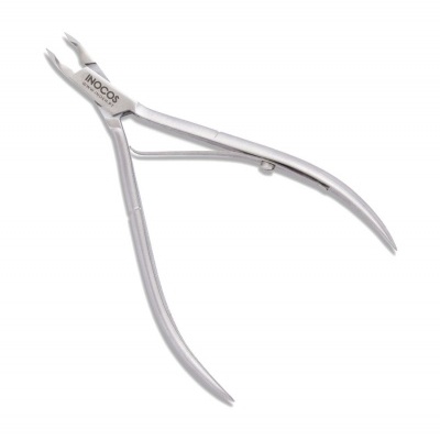 Alicate de cutículas de metal prateado com o texto INOCOS