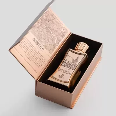 Frasco de perfume dourado em caixa marron aberta com mapa no interior