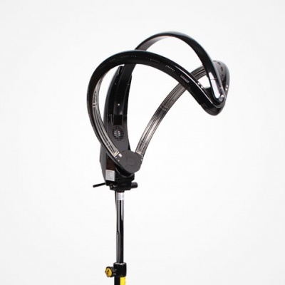 Aparelho preto com estrutura curva montado em suporte com base amarela