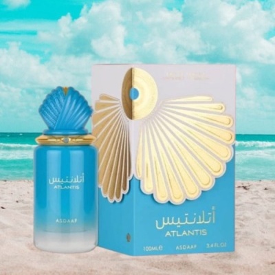 Frasco e caixa de perfume Atlantis sobre areia na praia com mar e céu azul