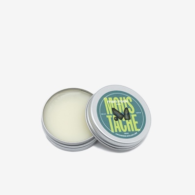 Lata metálica redonda com creme e rótulo verde 'NOIRS TACHE'