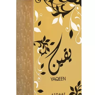Frasco de perfume amarelo com tampa dourada e decoração floral preta e branca
