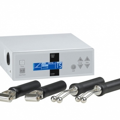 Aparelho electrónico com ecrã digital azul e branco e botões cinzentos, com quatro sondas metálicas e cabo preto.