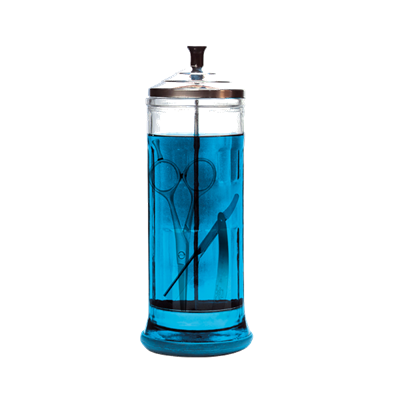 Recipiente cilíndrico com líquido azul e tesouras dentro