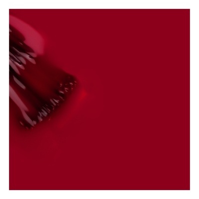 Pincel de maquilhagem vermelho com cerdas densas sobre fundo vermelho liso