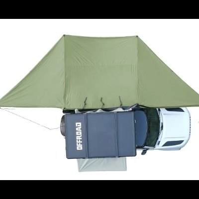 Tenda de campismo verde ao lado de uma viatura branca com estrutura preta no tejadilho com texto OFFROAD.