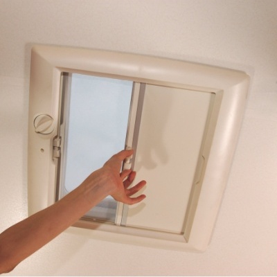 janela de teto quadrada branca com estore deslizante e mão ajustando