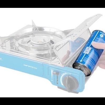 Fogão portátil a gás azul CAMPINGAZ com suporte metálico e lata azul de gás ao lado.