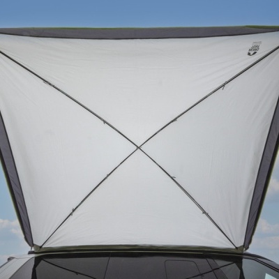 Toldo triangular branco com armação preta montado em topo de carro