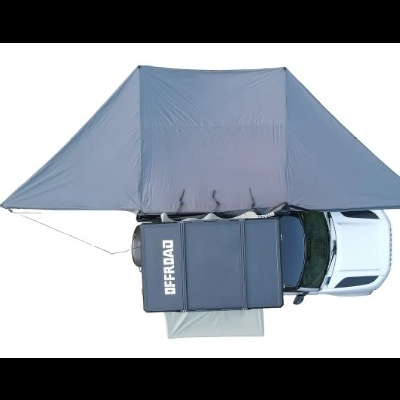Tenda de campismo cinzenta sobre carrinha branca com caixa preta Offroad, vista aérea