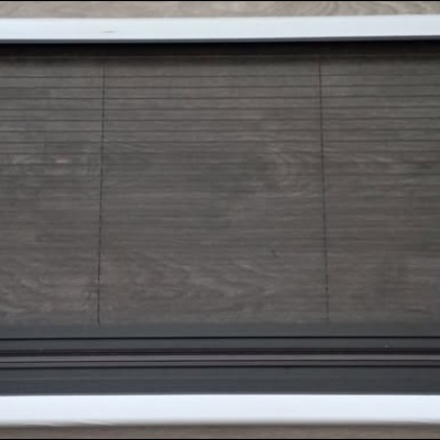 Suporte de vidro com estrutura de alumínio e cantos em plástico preto sobre chão de madeira clara