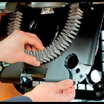 Mãos a ajustar correia em máquina com nome Dometic e prateleira com especiarias ao fundo.