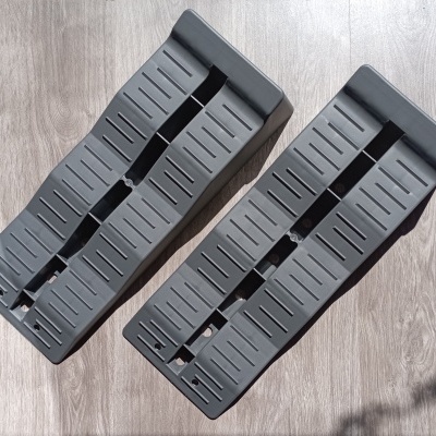 Par de rampas de plástico preto com ranhuras sobre chão de madeira clara