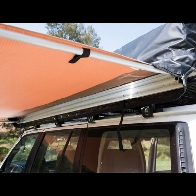 Toldo laranja instalado no teto de um veículo branco