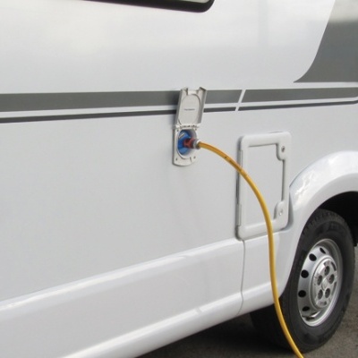 Veículo recreativo branco com mangueira amarela ligada