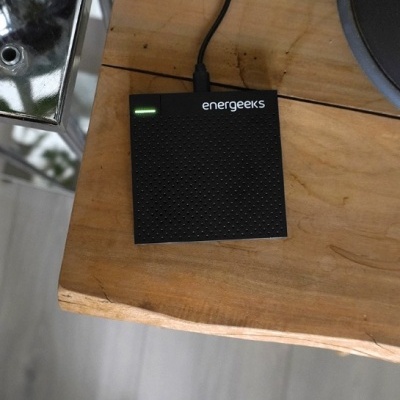 Dispositivo eletrónico preto energeeks em mesa de madeira clara