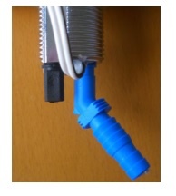 torneira com tubo flexível azul e conector preto em fundo de madeira