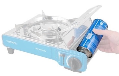 Fogão portátil a gás azul CAMPINGAZ com suporte metálico e lata azul de gás ao lado.