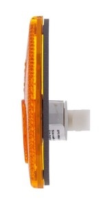 Luz de sinalização amarela com base preta e componente branco numa superfície branca