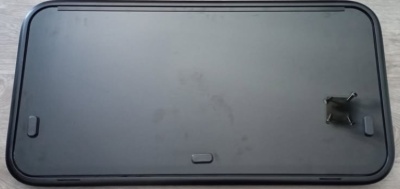 Tampa preta retangular com bordas arredondadas e três elementos retangulares em relevo.