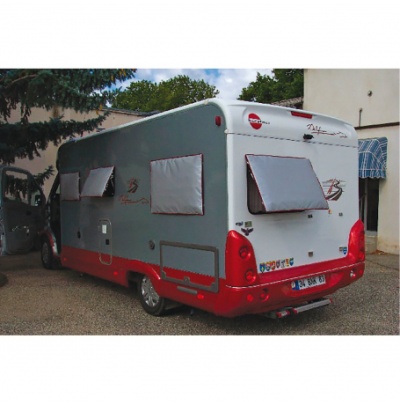 Autocaravana cinzenta e vermelha com janelas cobertas e autocolantes na traseira