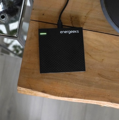 Dispositivo eletrónico preto energeeks em mesa de madeira clara