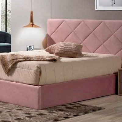 Cama estofada rosa com cabeceira geométrica e mesa de cabeceira numa divisão interior