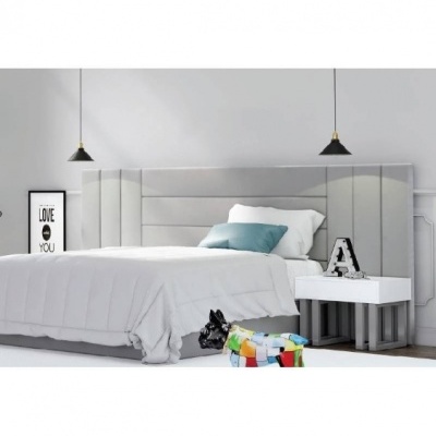 Quarto com cama de casal, cabeceira cinzenta, mesa de cabeceira branca, luminárias pretas e pufe colorido