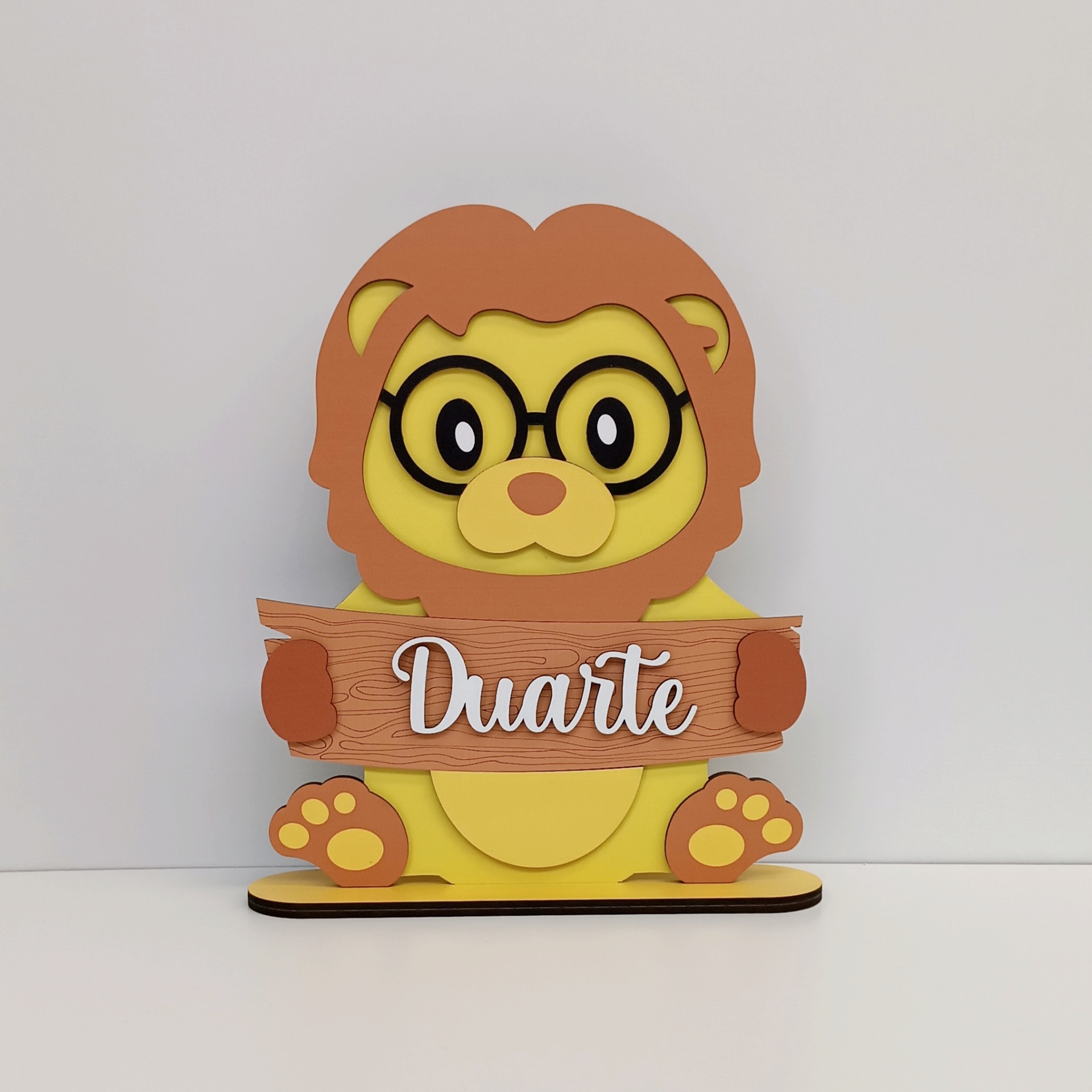 Placa de Quarto Personalizada com Nome - Leão Decoração em madeira leão amarelo castanho com óculos a segurar placa com texto Duarte