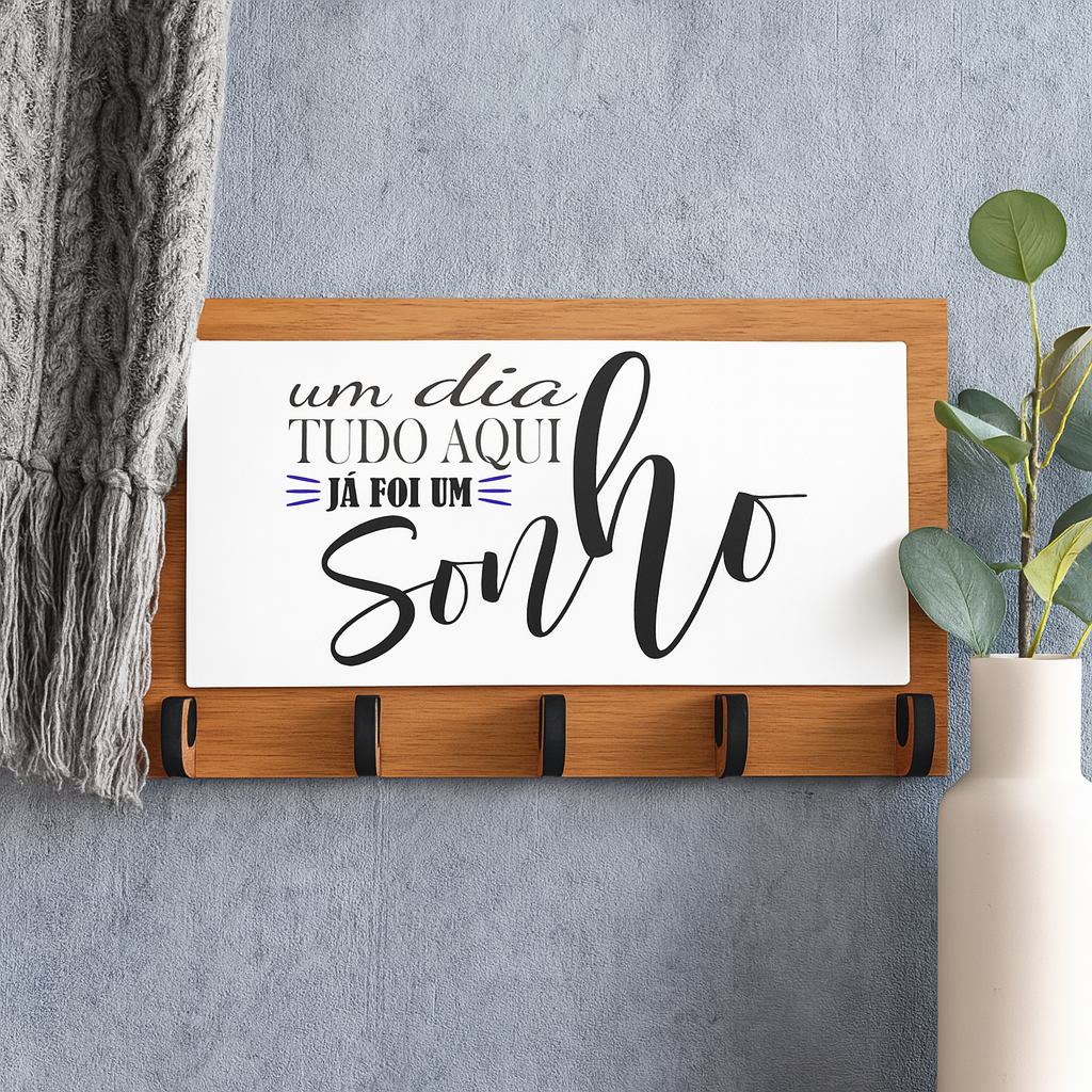 Chaveiro "Um dia tudo aqui já foi um sonho" Cabide de parede com texto decorativo em português, base de madeira com ganchos pretos pendurado na parede cinzenta