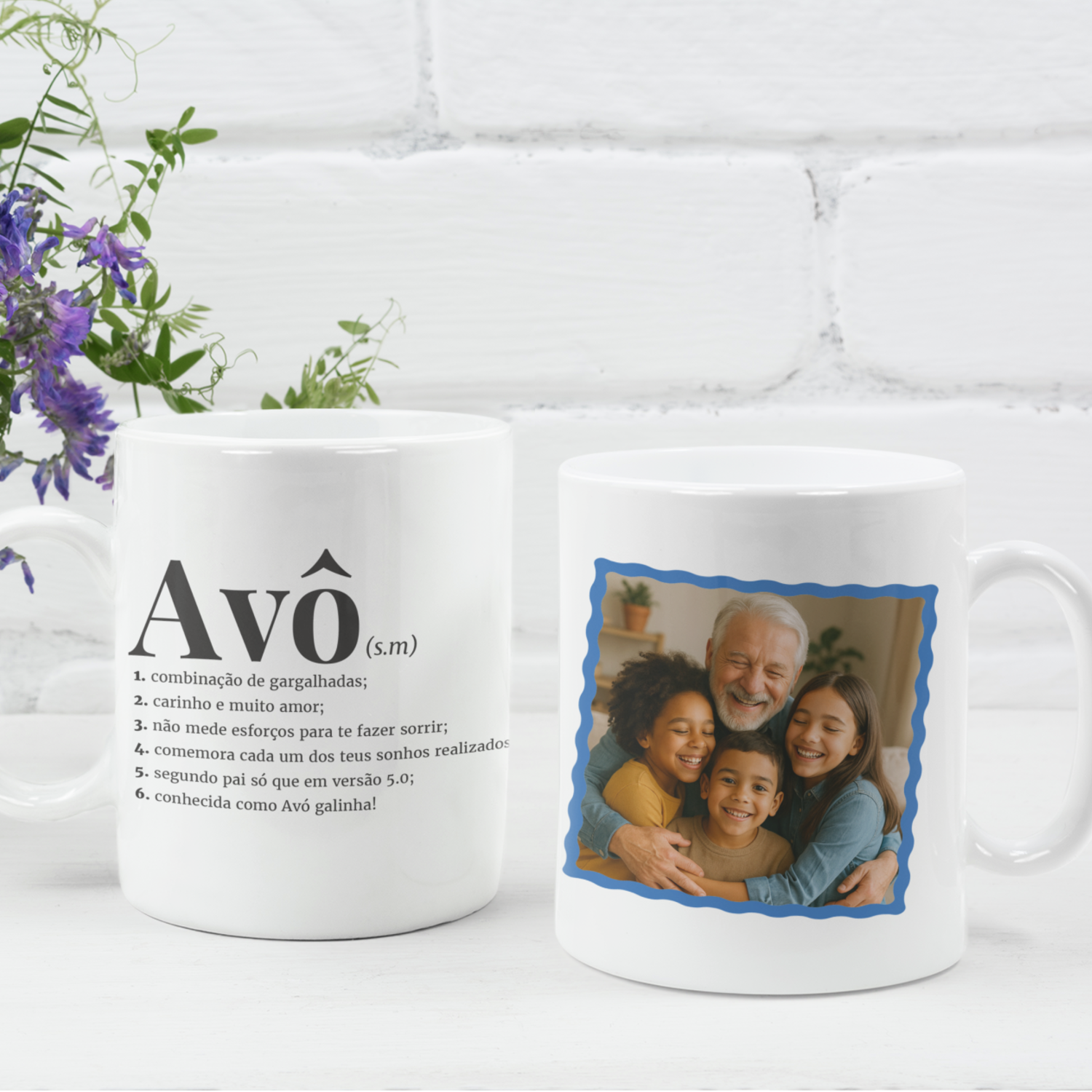 Caneca "Definição Avô" com Fotografia – Mod. 1 Duas canecas brancas com texto e foto, colocadas sobre superfície branca com flores ao lado