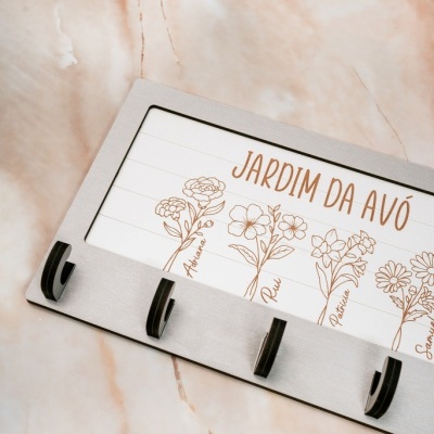 Suporte de parede metálico com ganchos e desenho de flores com texto Jardim da Avó
