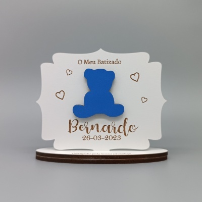 Placa decorativa branca com urso azul e texto O Meu Batizado Bernardo 26-03-2023 com corações dourados