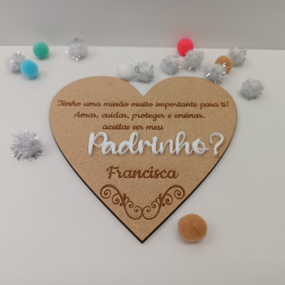 Placa coração de madeira com texto gravado e pompons coloridos e brancos em volta