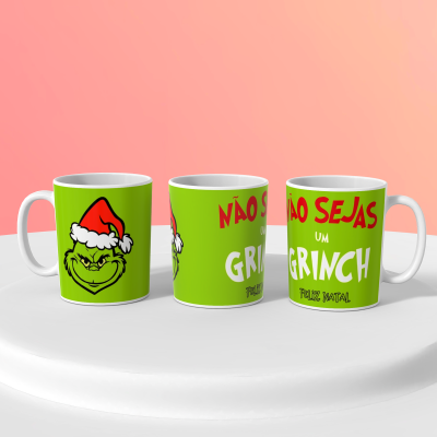 Três canecas verdes com ilustrações do Grinch e texto de Natal em fundo cor de rosa.