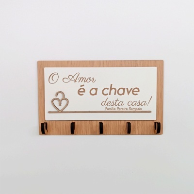 Porta-chaves em madeira com placa branca e texto em castanho e cinco ganchos metálicos pretos