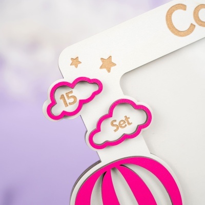 Detalhe de produto em papel com recortes de nuvens e balão cor-de-rosa
