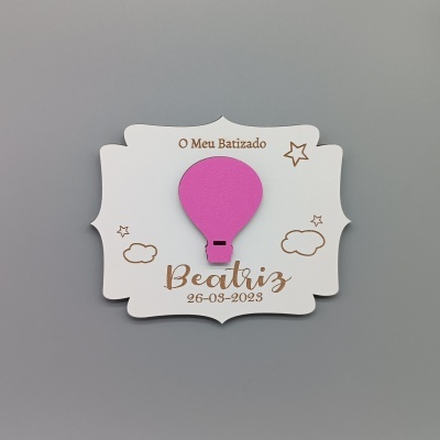 Cartão decorativo branco com balão cor-de-rosa e texto sobre batizado.