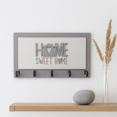 Suporte de parede com texto HOME SWEET HOME e cinco ganchos pretos, prateleira de madeira com pedra cinzenta e jarro com flores secas