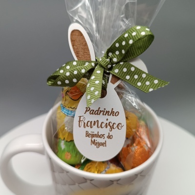 Caneca branca com chocolates embrulhados e etiqueta com texto