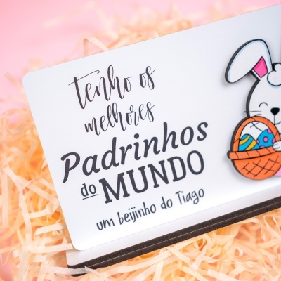 Cartão branco com texto em português e imagem de coelho colorido a segurar cesta de ovos