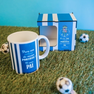 Caneca e caixa azul e branca com texto e escudo do FC Porto sobre relva artificial