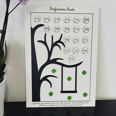 Quadro decorativo com árvore preta, baloiço e flores brancas com nomes de alunos