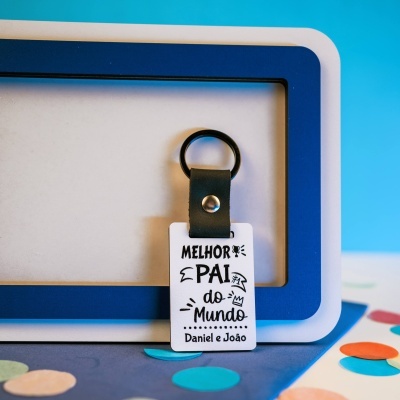 Porta-chaves com placa com texto Melhor Pai do Mundo Daniel e João em fundo colorido.