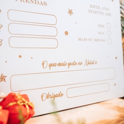 Cartão branco de Natal com texto dourado e espaços para preencher desejos e preferências