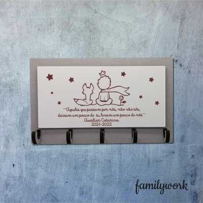 Cabideiro de parede cinza com placa branca decorativa com raposa e menino sentados e texto em português