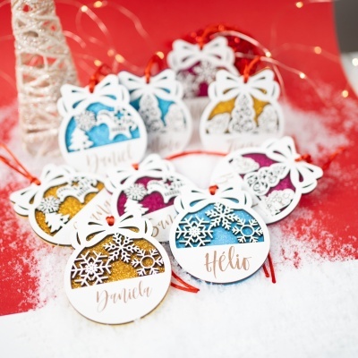 Ornamentos de Natal em madeira branca com detalhes em glitter e nomes escritos